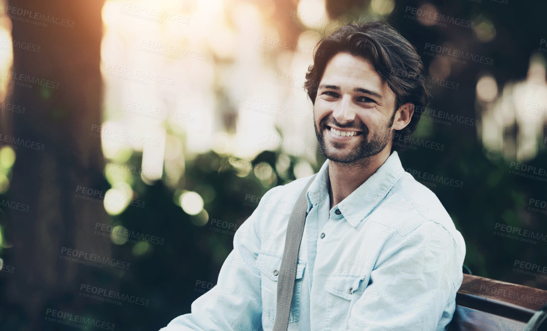 Buy stock photo Travel, relax and portrait of a man on a park bench for a break, morning commute or summer. Smile, nature and a young person or tourist in a public garden for tourism, sightseeing or a vacation