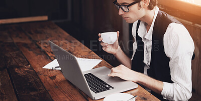 Buy stock photo Shot of a young man sitting in a cafe working on a laptop