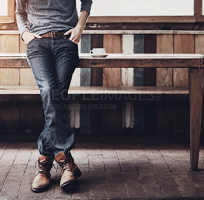 Buy stock photo Fashion, casual and closeup of a man at a coffee shop with a trendy, cool and stylish outfit. Shirt, denim jeans and zoom of a male person with edgy style standing at a wood table in a cafeteria.