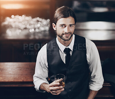 Buy stock photo Portrait of a well-dressed young man sitting at a bar with a drink