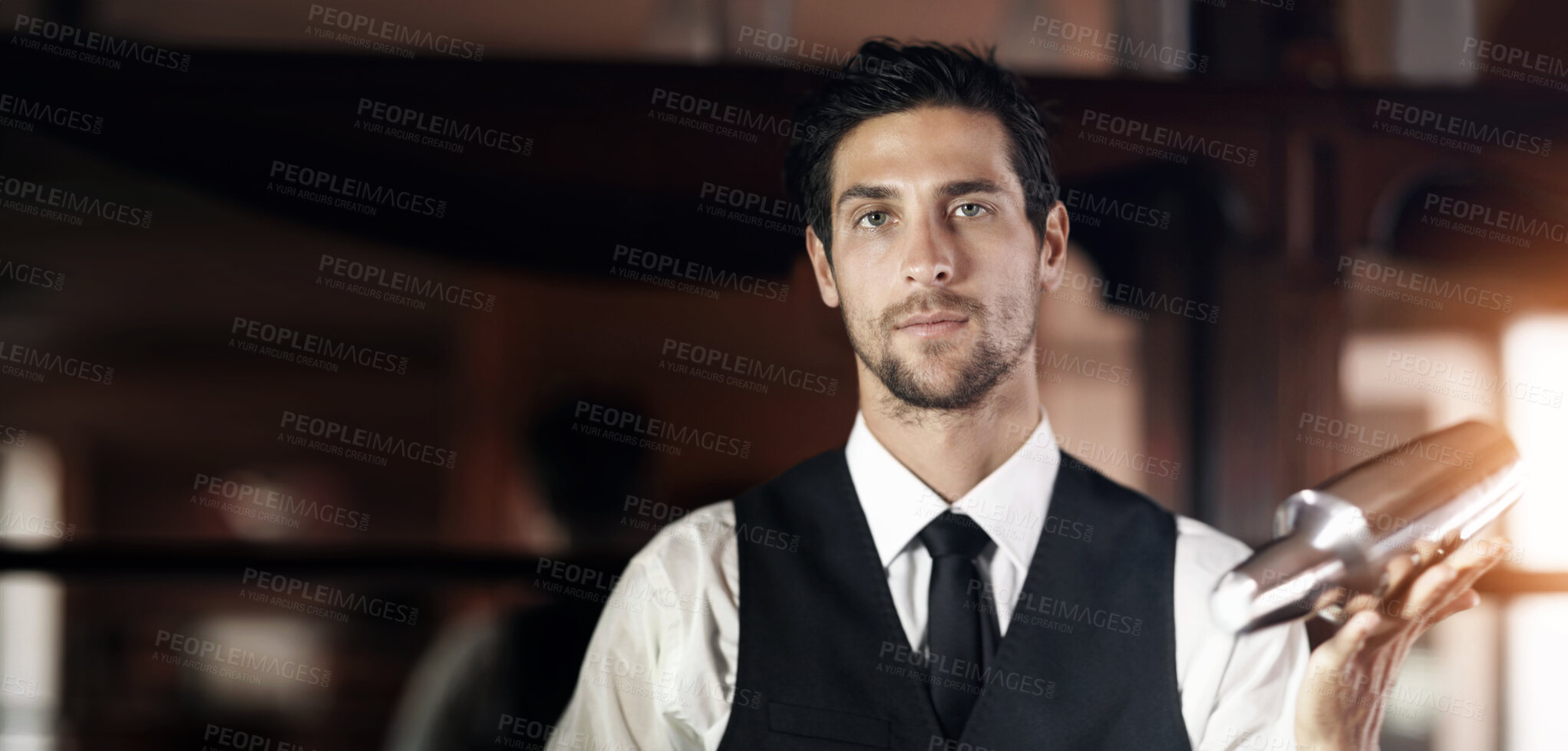 Buy stock photo Portrait of a handsome young bartender mixing a cocktail for a customer