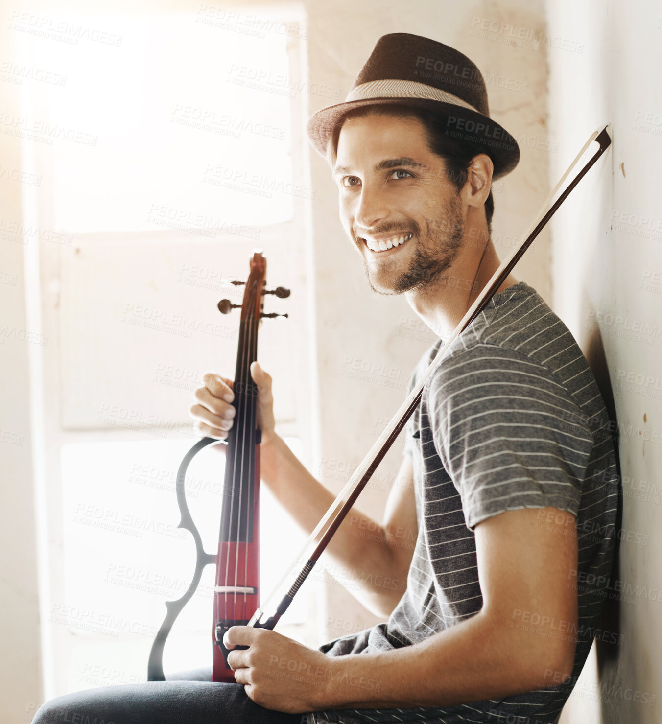 Buy stock photo Handsome young musician holding his violin on a stairwell