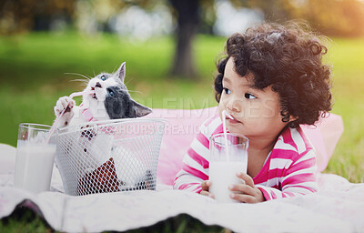 Buy stock photo Milk, picnic and a girl in the park with her kitten together for love, care or bonding during summer. Summer, straw or kids and happy young child in the garden drinking from a glass with her pet cat