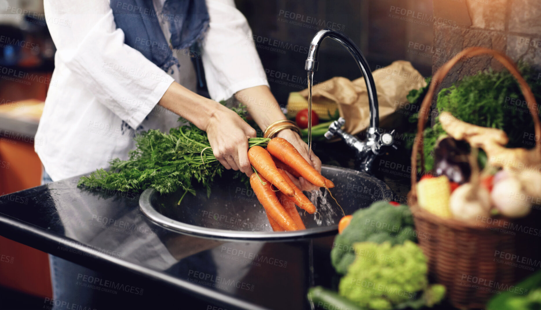 Buy stock photo Cropped view of a woman washing fresh vegetables in her kitchen sink