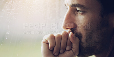 Buy stock photo A young looking pensive while covering his mouth with a clenched hand