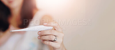 Buy stock photo A young mother holding her toddler boy while looking at a thermometer