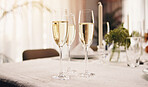 Alcohol, champagne and glass on table at party for celebration, social event and gathering. Fine dining, luxury and liquor bubbles for cheers, toast and drinks at gala, new years eve and dinner