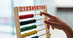 Hand, abacus and child learning math for brain development, study or arithmetic. Kid, person and calculate with beads for education, knowledge or student counting numbers in elementary school closeup