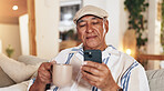 Senior man, phone and coffee in home with retirement, relax and morning scroll with online game. Tea, calm and digital news app with reading, mobile and tech in living room with latte and internet