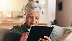 Old woman, relax and tablet for communication in home, reading notification and texting on app. Female person, senior lady and couch for scroll on social media, ebook and website for news update