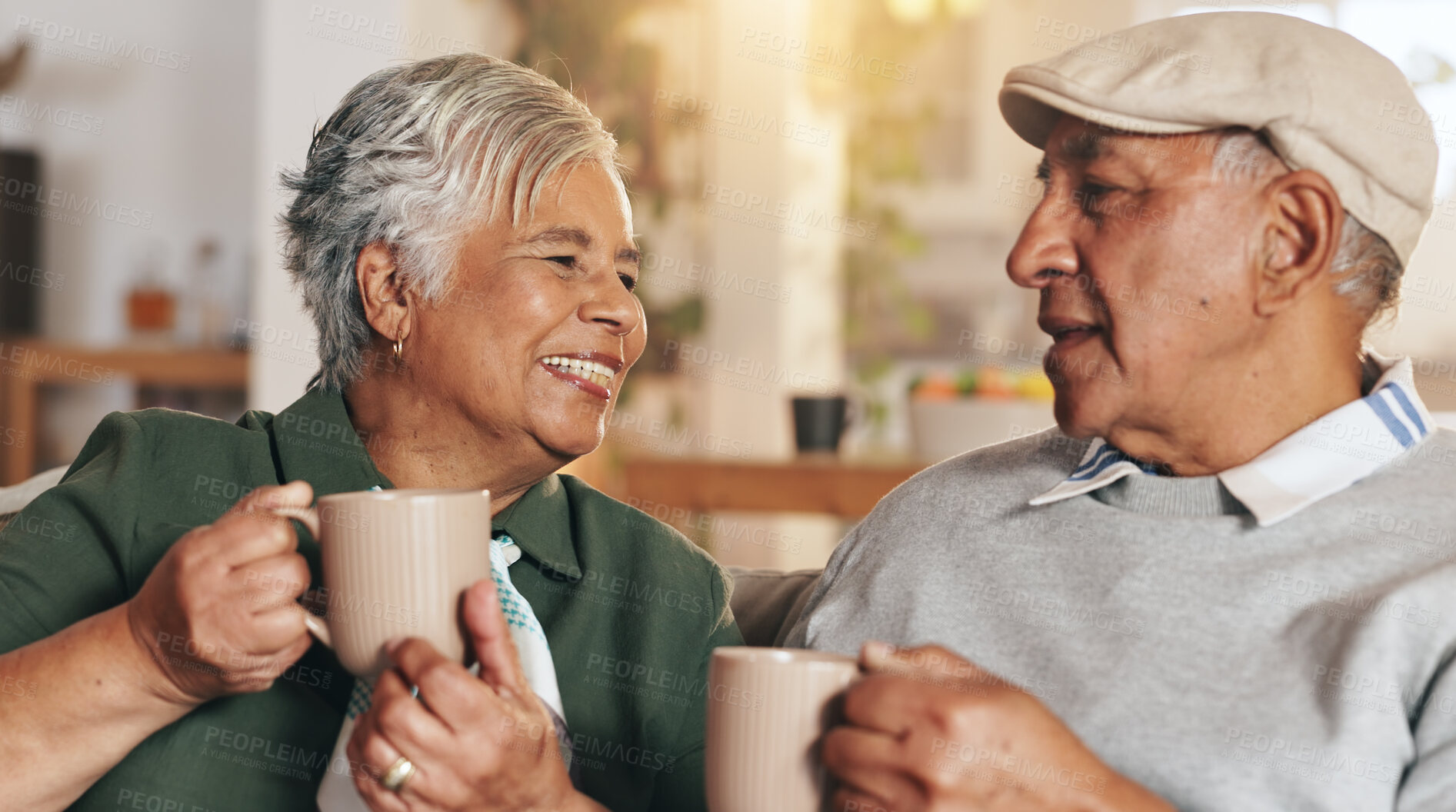 Buy stock photo Retirement, old couple and smile for coffee, bonding and conversation in morning, love and happy in house. Living room, relax and nostalgia of relationship, talking and senior people with cups