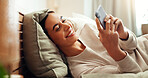 Phone, happy and woman on bed in home with social networking, browsing and swiping on dating app. Calm, relax and female person laying in bedroom with cellphone for reading online blog in apartment.