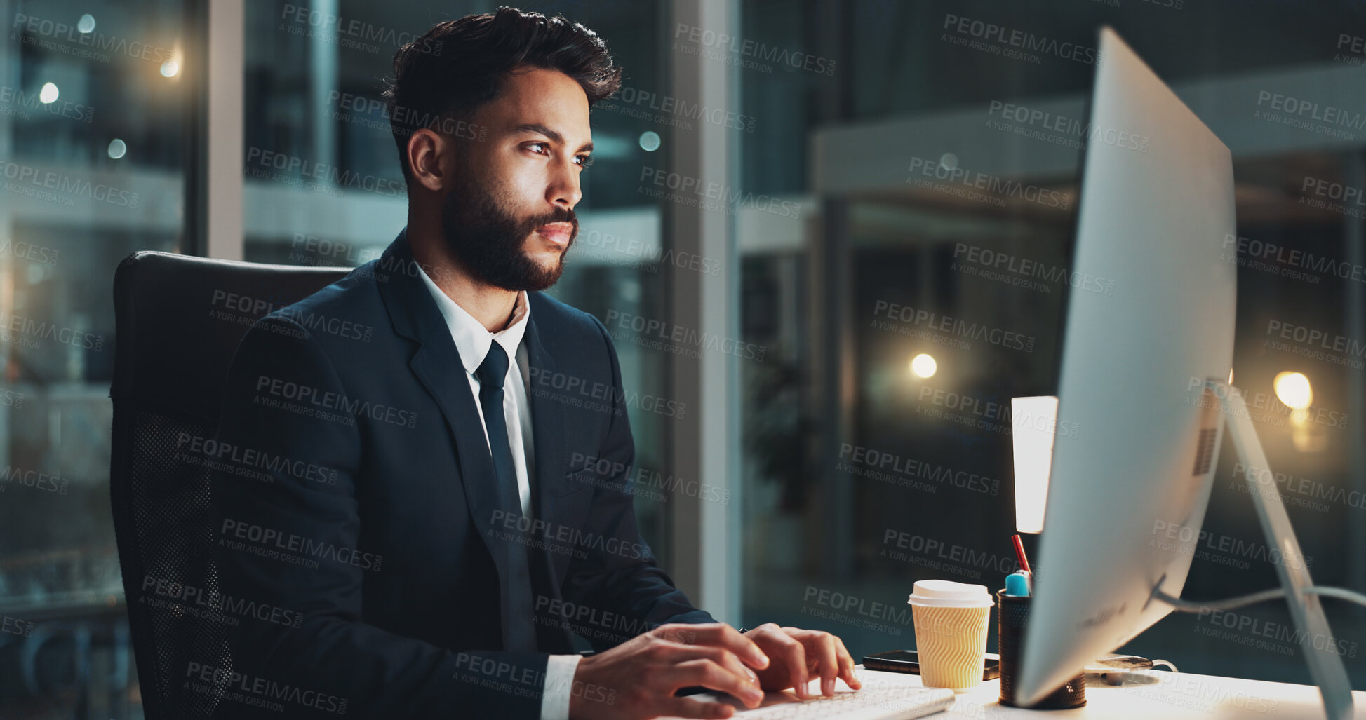 Buy stock photo Computer, night and serious with business man at desk in office for administration or research. Information, reading and report with confident employee typing on PC for deadline or overtime at work