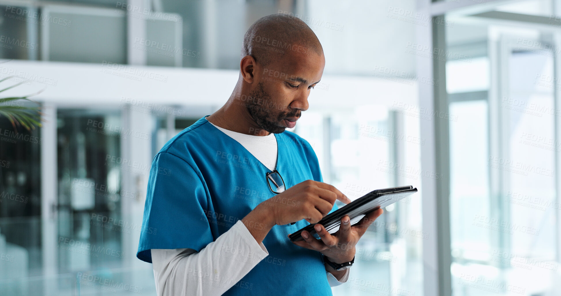 Buy stock photo Black man, nurse and clinic with tablet on telehealth for patient appointment, consultation and information. Male person, employee and serious with browsing internet for healthcare, data and records