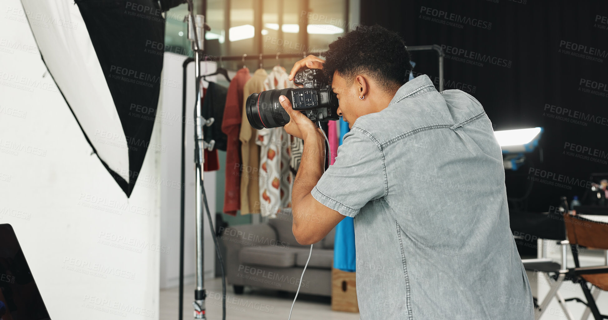 Buy stock photo Photography, fashion and creative with man in studio for magazine production, backstage and wardrobe set. Artist, photoshoot and camera with person for ecommerce catalog, shooting and picture