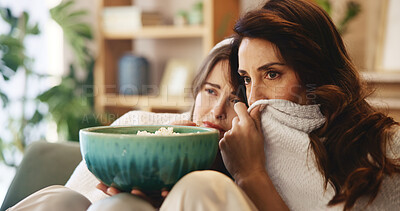 Buy stock photo Scary, movie and mature mother with daughter on sofa for bonding, television show or popcorn in living room. Weekend, streaming and mom on couch with girl watching tv, horror or fear in home together