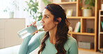 Home, woman and drinking water for health after yoga, practice and mindfulness session for wellness. Fitness, female person and yogi on break with beverage bottle, detox or hydration with mineral H2O