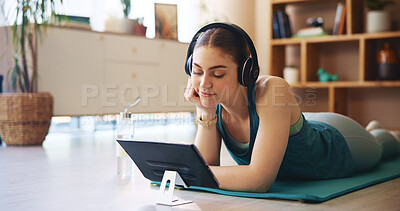 Buy stock photo Yoga, headphones and woman on tablet relax in home for wellness, health and workout for online class. Happy, music and person on floor on digital tech after exercise, training and watching videos