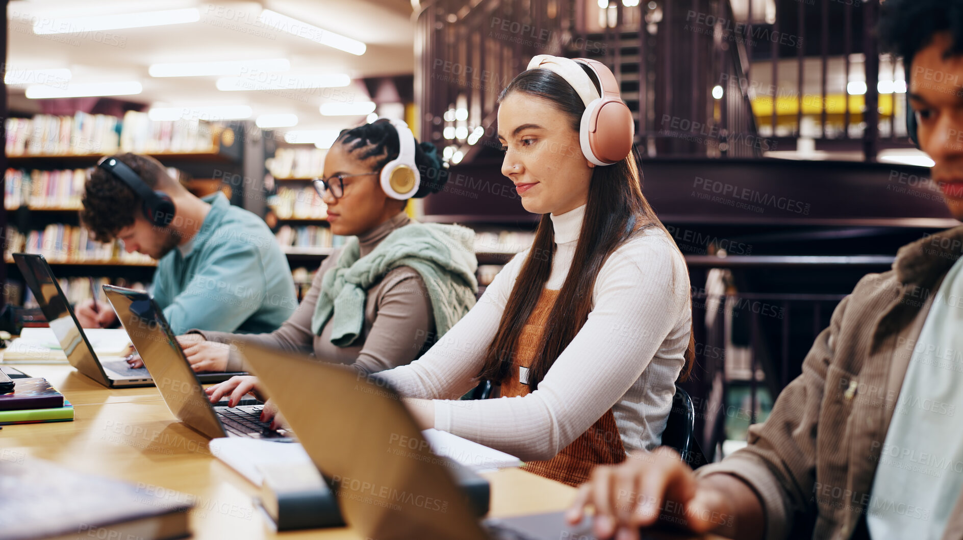 Buy stock photo People, studying and laptop in library with headphones, planning and working on research assignment. Student group, exam preparation and music with tech for education, connectivity and online course