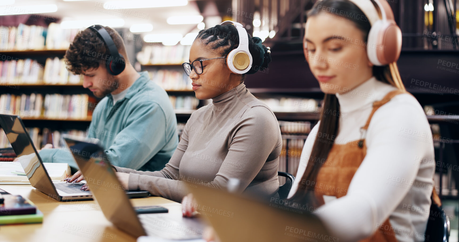 Buy stock photo People, learning and laptop in library with headphones, planning and working on research assignment. Student group, exam preparation and music with tech for education, connectivity and online course