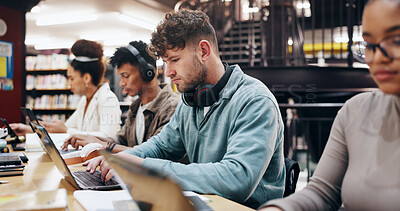 Buy stock photo Man, studying and laptop in library for education, problem solving and working on research assignment. Student group, headphones and computer at college for learning, online course and productivity