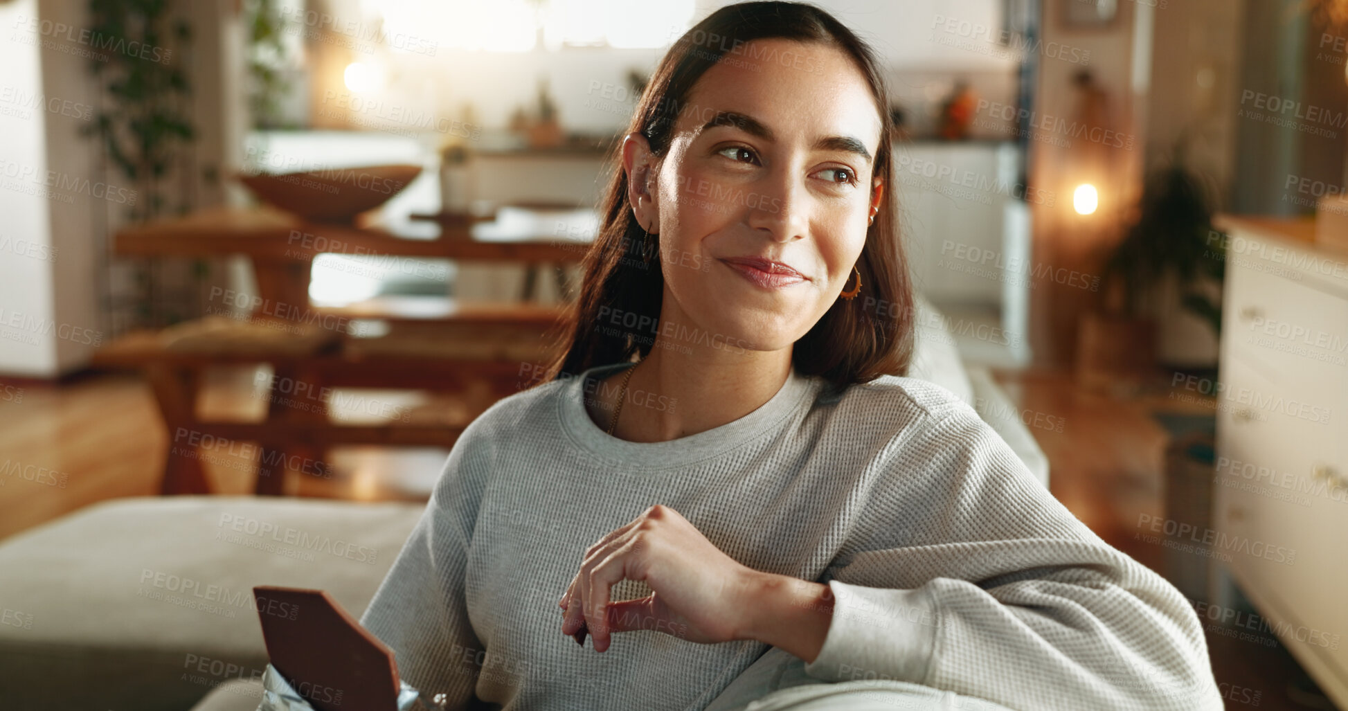 Buy stock photo Chocolate, happy and thinking with woman on sofa in living room of home for relax or wellness. Candy bar, idea and smile with face of person eating sweets in apartment for vision or weekend time off