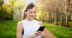 Girl, smile and phone in nature with fitness for running performance, tracking speed and marathon monitor. Athlete, runner and biometric in forest for wellness progress, music or earphones outdoor