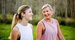 Mother, daughter or talking in forest with hiking for fitness adventure, sightseeing or explore nature. Laughing, mature woman or girl in woods with walking, holiday travel or bonding on outdoor path