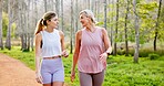 Mother, daughter or talking in nature with hiking for fitness adventure, sightseeing or explore forest. Exercise, mature woman or girl in woods with walking, holiday travel or bonding on outdoor path