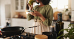 Ingredients, pan and stove with woman in kitchen for cooking dinner, healthy meal and preparing lunch. Kitchenware, person and closeup pf seasoning, spices and sauce in home for nutrition and food