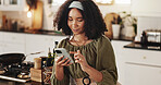 Woman, typing and phone in kitchen for social media, text message and research recipe ideas. Girl, mobile and scroll on internet in home for connectivity, communication and smile for weekend planning