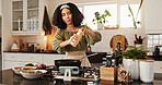 Woman, cooking or pan with ingredients for seasoning, stir fry or flavour to meal, food or vegetables in kitchen at home. Female person, chef or organic ingredients for stove, adding spice or recipe