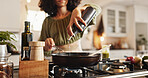 Woman, hands and cooking with oil in pan for ingredients, recipe or meal prep in kitchen at home. Female person, chef and pouring liquid with organic food on stove for spice, flavor or taste at house