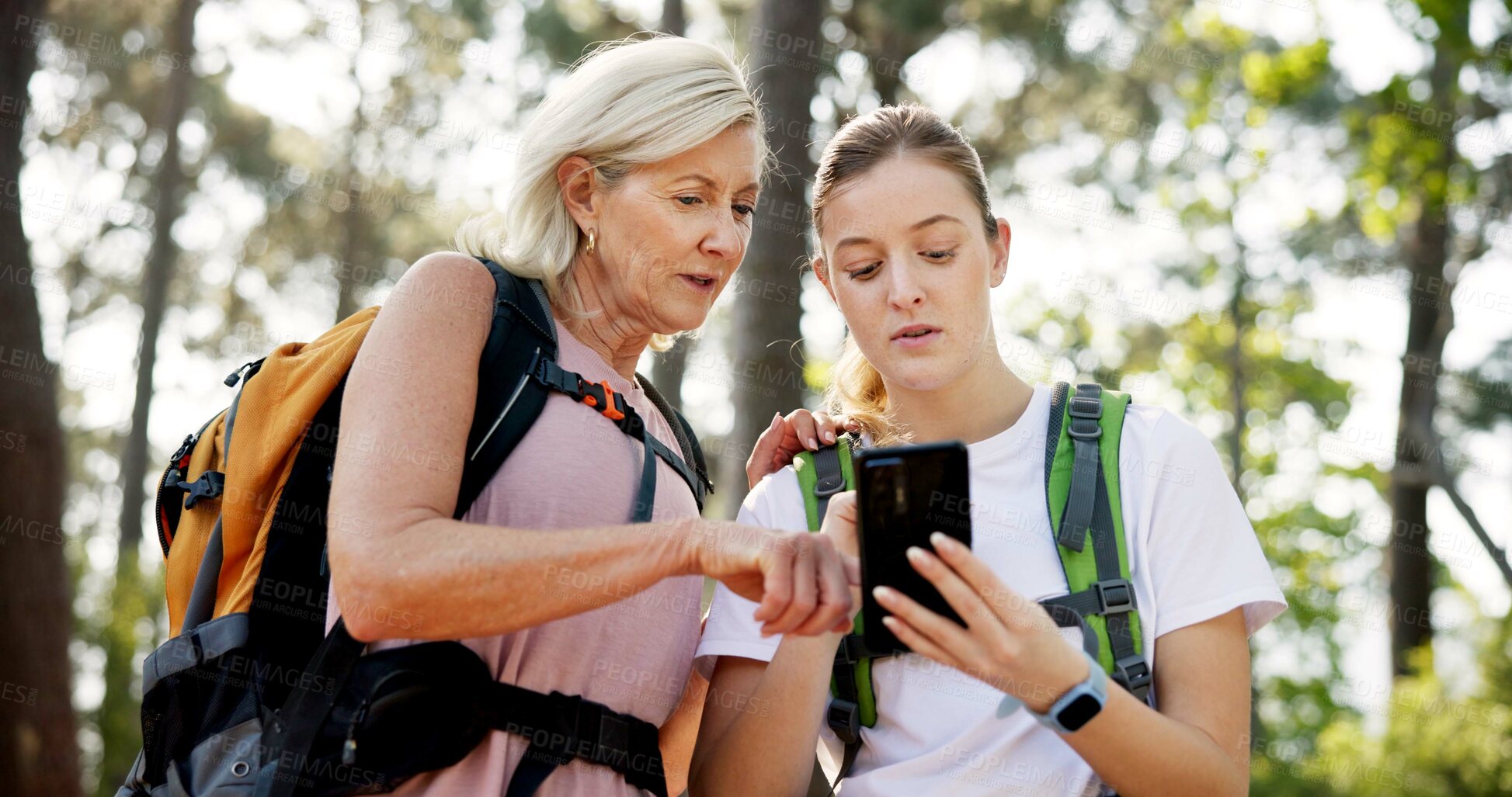 Buy stock photo Mother, adult daughter and cellphone with hiking, app or fitness with vacation, bonding together and network. Nature, outdoor or hiker with smartphone or woods with trees, travel or direction