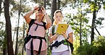 Women, textbook and hiking with binoculars in forest for bird watching, sightseeing or outdoor discovery in nature. Female people, friends or hikers with book for tourism, trekking or observation