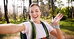 Happy woman, portrait and hiking with backpack for video call, travel memory or live streaming adventure in forest. Female person, influencer or smile with bag or wave for trekking journey in woods