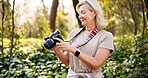 Mature woman, photographer and camera in forest with smile, check and creativity for nature magazine. Journalist, photography and decision for project, research and ideas for conservation in Brazil