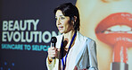 Woman, presentation and speaker at convention with beauty, evolution and stage with mic for skincare. Person, speech and announcement for makeup, cosmetics and information at international conference