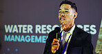 Stage, presenter and man at seminar with microphone,  presentation and ideas for water management. Climate change, resources and speaker at screen for conference on global solution for sustainability