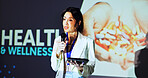 Presentation, conference and woman on a stage for healthcare tradeshow, convention and seminar. Public speaking, audience and person on tablet at event for pharmaceutical, wellness or medical service