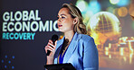 Stage, presenter and woman at seminar with microphone,  tablet and global economic recovery ideas. Trade, resources and speaker at screen for conference on financial development, growth and solution