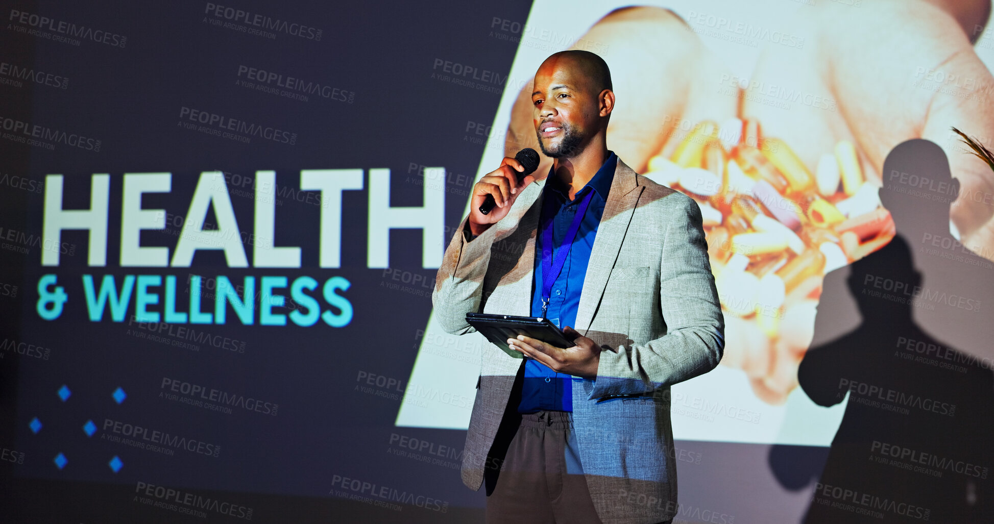 Buy stock photo Presentation, conference and man on a stage for medical tradeshow, convention and seminar. Public speaking, audience and person on tablet at event for healthcare, wellness and hospital accessibility