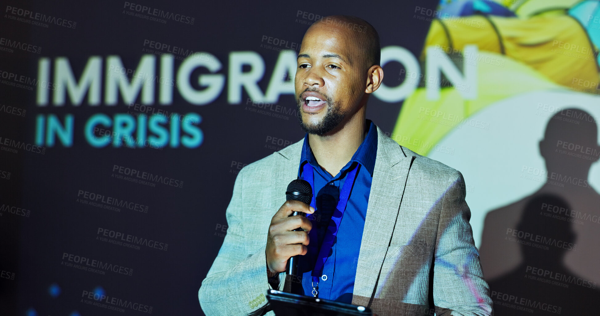 Buy stock photo Seminar, speaker and black man at screen for global immigration with microphone, tablet and presentation. Ideas, change and presenter on stage for conference on international refugee crisis forum