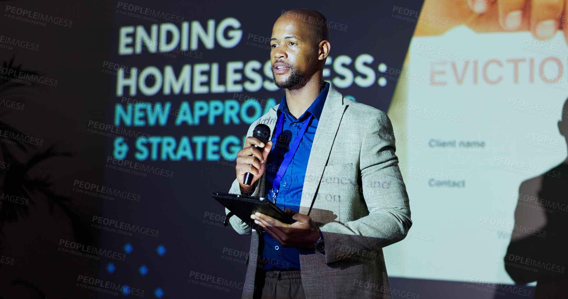 Buy stock photo African man, presentation and stage at convention for homeless crisis with call to action for problem solving. Person, speaker and housing activist with speech, tablet and strategy at conference