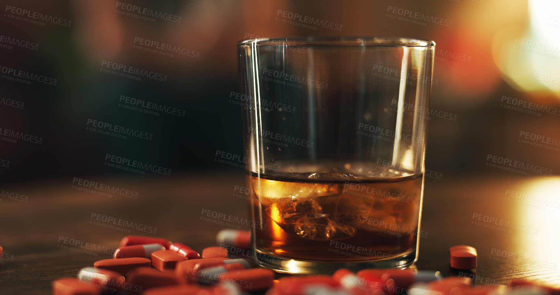 Buy stock photo Drugs, pills and alcohol on table in dark apartment with opioid crisis, crime and danger. Risk, substance abuse and medicine with drink glass, pharmaceutical narcotics or toxic habit in home at night