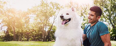 Buy stock photo Shot of a handsome young man walking his dog in the park