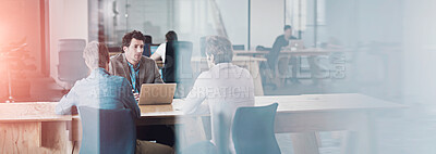 Buy stock photo Through the glass shot of a group of colleagues working together in an office