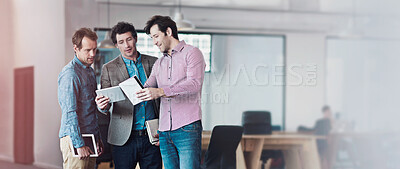 Buy stock photo Shot of a group of male coworkers taking over a digital tablet in an office