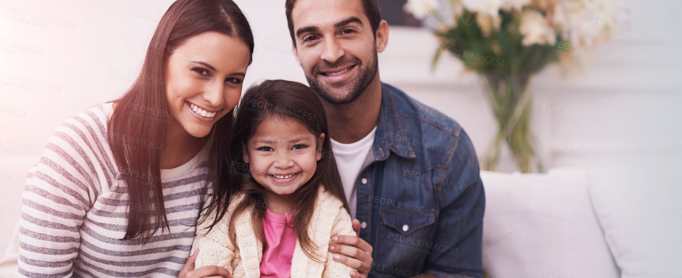 Buy stock photo Portrait of a happy young family sitting together at home