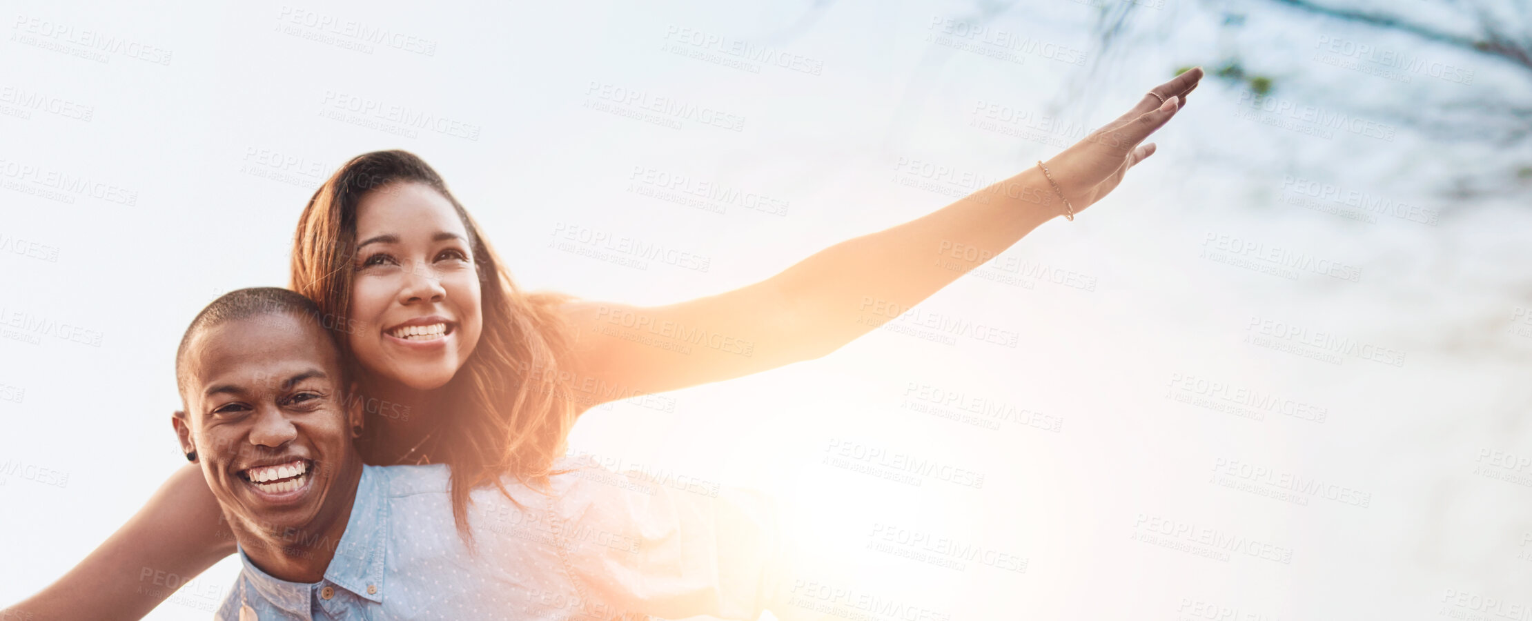 Buy stock photo Portrait of a happy young couple enjoying a piggyback ride outdoors